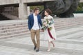 Just married loving couple in wedding dress and suit . Happy bride and groom walking running in the summer city. Royalty Free Stock Photo