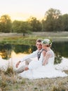 Just married loving hipster couple in wedding dress and suit on green field in a forest at sunset. happy bride and groom Royalty Free Stock Photo