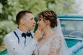 Just married wedding couple is standing near the retro vintage car in the park. Summer sunny day in forest. bride in Royalty Free Stock Photo