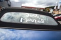 Just married white inscription on rear window of blue cabriolet car with black convertible roof. Wedding day concept. Royalty Free Stock Photo