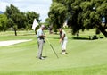 Just missing that make or break put. A senior woman putting for birdie during a round of golf with her husband. Royalty Free Stock Photo