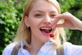 Just one more reason to smile. Pretty woman with happy smile. Happy woman hold cherry berries in healthy teeth. Sensual