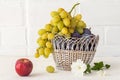 Just picked plums and grapes in wicker basket on white backdrop Royalty Free Stock Photo