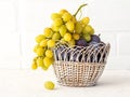 Just picked plums and grapes in wicker basket on white backdrop Royalty Free Stock Photo