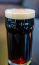 Just poured glass of beer standing on the wooden table Royalty Free Stock Photo