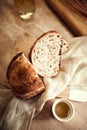 Just prepared, delicious, hot homemade, cut loaf of bread with golden brown crispy crust lying in natural fabric on Royalty Free Stock Photo