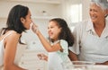 Just a quick little powder. a young girl playfully putting flour on her mothers nose during baking.