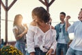 Just relax. Pretty and young woman in white shirt is smiling while standing on rooftop terrace with her friends Royalty Free Stock Photo