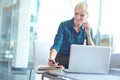 Just sending a quick message to my husband...a casual business woman sitting behind her laptop checking her phone with Royalty Free Stock Photo