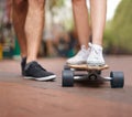 Just he skateboard essentials. Waist down shot of two people standing with a skateboard. Royalty Free Stock Photo