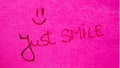 Just smile handwriting text close up isolated on pink paper with copy space. Writing text on memo post reminder Royalty Free Stock Photo