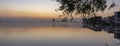 Just before sunrise, during a windless and misty morning, the houses on lake Noordhovense plas are reflected in the water