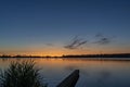 Just after sunset, the sky colors beautifully above lake Zoetermeerse plas with a breakwater in the foreground and a fishing boat Royalty Free Stock Photo