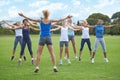 Just ten more. A group of young women doing jumping jacks on a sportsfield. Royalty Free Stock Photo