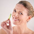 Just the thing to freshen up your skin. Cropped studio portrait of a mature woman holding up a slice of cucumber. Royalty Free Stock Photo