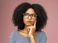 Just thinking about life. a beautiful young woman looking thoughtful against a pink background. Royalty Free Stock Photo