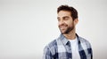 Just thinking about things. Studio shot of a cheerful young man standing against a white background while looking Royalty Free Stock Photo