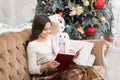 Just want a nice winter read. Adorable little girl read Christmas story to toy friend. Happy small child read book by Royalty Free Stock Photo
