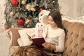 Just want a nice winter read. Adorable little girl read Christmas story to toy friend. Happy small child read book by Royalty Free Stock Photo