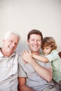 He just wants to be close to his dad. Cropped portrait of a handsome man sitting with his father and his son.