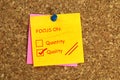 Focus on quantity quality postit on cork Royalty Free Stock Photo