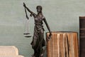 Justice figure and old books on a wooden background