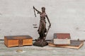 Justice figure and old books on a wooden background