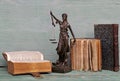 Justice figure and old books on a wooden background