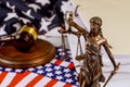 Justice holding the scales of justice with unfinished documents on law office table on American flag Legal office Royalty Free Stock Photo