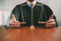 justice and law concept.Male judge in a courtroom with the balance scaleon wood table,reflected view Royalty Free Stock Photo