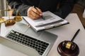 Justice and law concept.Male judge in a courtroom with the gavel, working with, computer and  docking keyboard, eyeglasses, on Royalty Free Stock Photo