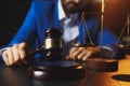 Justice and law concept.Male lawyer in the office with brass scale on wooden table, Royalty Free Stock Photo