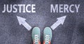 Justice and mercy as different choices in life - pictured as words Justice, mercy on a road to symbolize making decision and