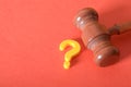 Justice in Question: Gavel and Question Mark on Red Background Represent Legal Doubts Royalty Free Stock Photo