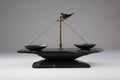 A justice scale with a bird on the balanced side and rocks on the unbalanced side.. AI generation