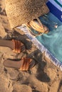 Jute beach bag and flip flops on the striped towel on the sand. Royalty Free Stock Photo