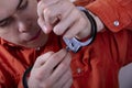 A juvenile delinquent tries to open the handcuffs with a paper clip.concept: attempt to escape from custody, opening locks, violat