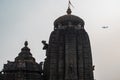 Juxtaposition of an airplane flying over Chitrakarini Temple in Bhubaneswar, Odisha, India