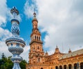 Juxtaposition of blue and white ceramic azulejo tiles against one of the baroque sandstone tower at Plaza de Espana in Seville, Sp Royalty Free Stock Photo