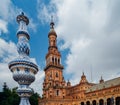 Juxtaposition of blue and white ceramic azulejo tiles against one of the baroque sandstone tower at Plaza de Espana in Seville, Sp Royalty Free Stock Photo