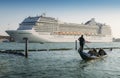 Juxtaposition of gondola and huge cruise ship in Giudecca Canal. Old and new transportation on the Venice Lagoon Royalty Free Stock Photo