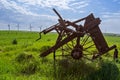 Old and new technology - wind turbines and abandoned plough Royalty Free Stock Photo