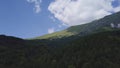 4k aerial drone footage of mountain side with evergreen forest and clouds