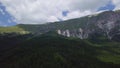 4k aerial drone footage of mountain side with evergreen forest and clouds