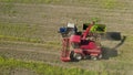 4K Aerial Elevated View Of Combine Harvester And Tractor Working Together In Field. Harvesting Of Oilseed In Spring