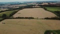 4k flying over farmers baying hay in their field during summertime in England.