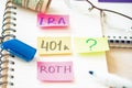 401k ira roth on pieces of colorful paper dollars on table. Pension concept. Retirement plans