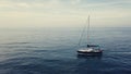 4k lateral aerial of sailing boat in sunset cloudscape, boat leaves the scene