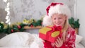 4k little girl shakes gift box to find out what is inside. Fulfilling children Christmas wishes, dreams and surprises