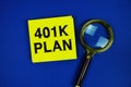 401K Plan text on sticky note with magnifying glass on navy blue background Royalty Free Stock Photo